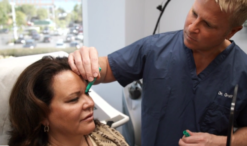 cosmetic laser dermatology doctor examining patient for sagging eyebrows san diego ca