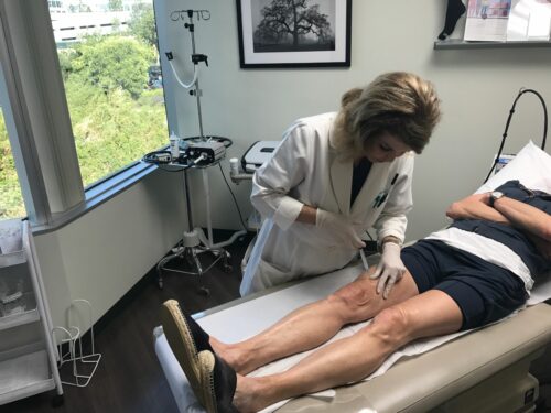 Dr. Butterwick is injecting sclerotherapy injections onto her patient's legs to treat leg veins in San Diego, CA.