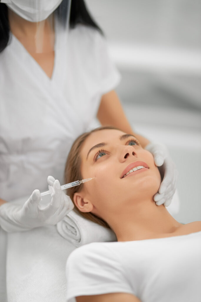 smiling woman getting a dermal filler in san diego