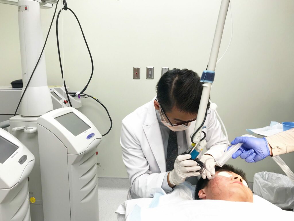 Dr. Wu performing a laser treatment on a patient with skin of color in San Diego